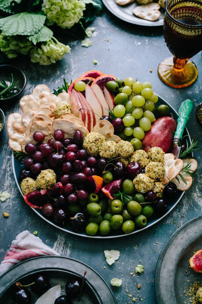 Healthy platter with fruit, cheese balls, rice crackers and olives
