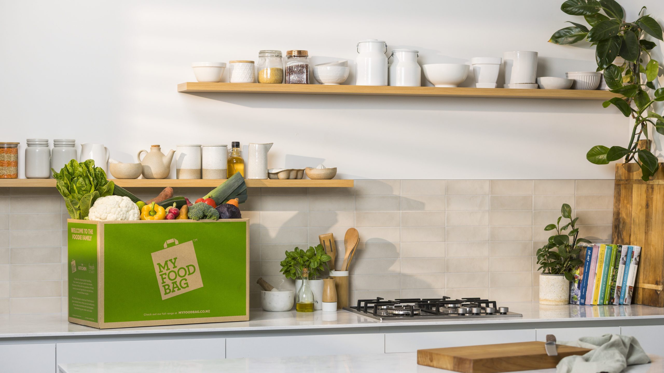 What is a Meal Kit? How Meal Kit Delivery Works in New Zealand 1 Fresh produce and seasonal vegetables packed inside a green My Food Bag food box on a bright, clean kitchen counter ready for home cooking.